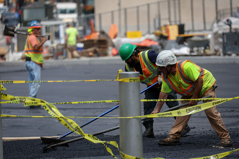 Workers spread hot asphalt on a road, after New York City issued an excessive heat warning, during hot weather in lower Manhattan in New York City, New York, U.S., July 27, 2023