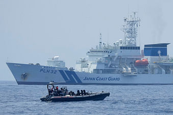 A Philippine Coast Guard rigid hull inflatable boat passes by the Japanese Coast Guard Akitsushima (PLH-32) during a trilateral Coast Guard drill of the U.S., Japan and Philippines, near the waters of the disputed South China See in Bataan province, Philippines, on 6 June 2023