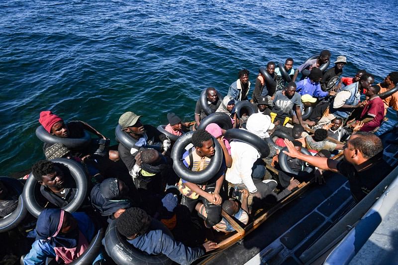 Migrants of African origin trying to flee to Europe are crammed on board of a small boat, as Tunisian coast guards prepare to transfer them onto their vessel, at sea between Tunisia and Italy, on 10 August 2023