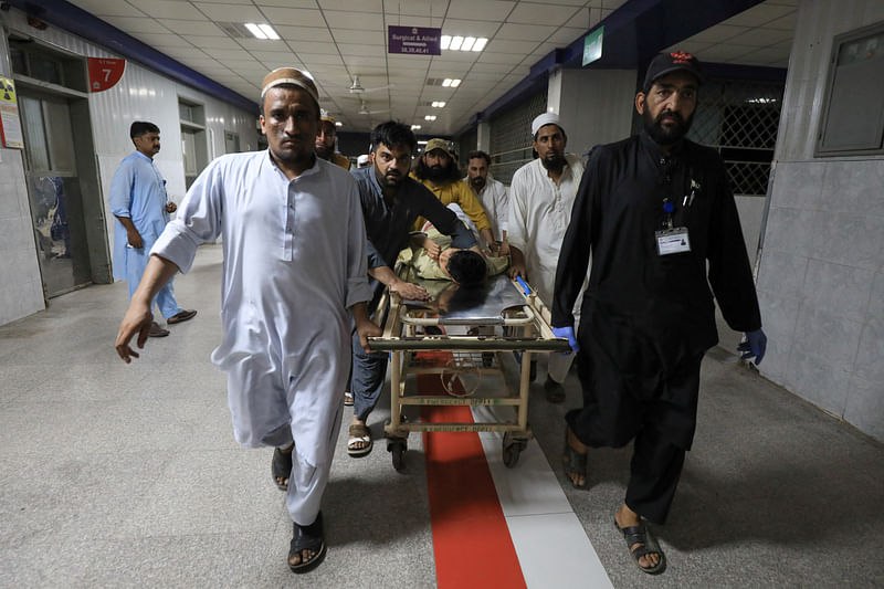 People transport a man, who was injured after a blast in Bajaur district of Khyber Pakhtunkhwa, at the Lady Reading Hospital in Peshawar, Pakistan 30 July, 2023