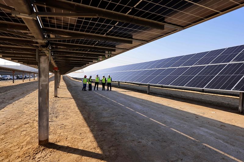 Employees stand at a Solar Photovoltaic (PV) Independent Power Producer (IPP) project, in Abu Dhabi on January 31, 2023