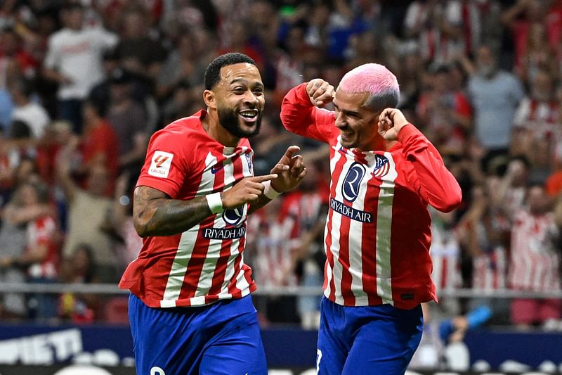 Atletico Madrid's Dutch forward Memphis Depay celebrates with Atletico Madrid's French forward Antoine Griezmann scoring his team's second goal during the La Liga match between Club Atletico de Madrid and Granada FC at the Wanda Metropolitano stadium in Madrid on 14 August 2023