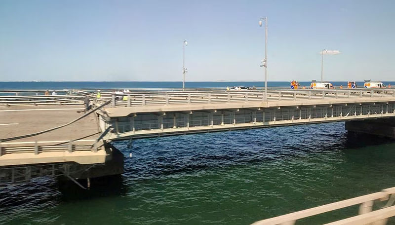 A view through a train window shows the section of a road split and sloping to one side following an alleged attack on the Crimea Bridge, that connects the Russian mainland with the Crimean peninsula across the Kerch Strait, in this still image from video taken on 17 July, 2023.