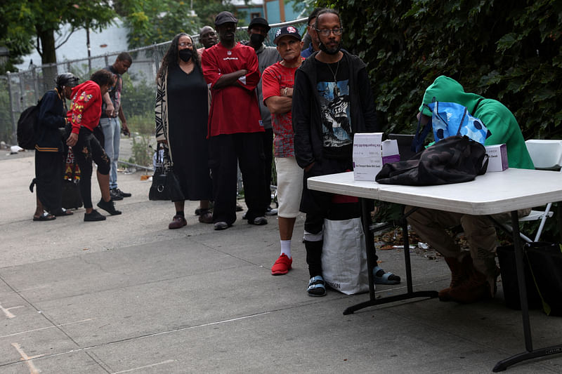 People wait in line to take a COVID-19 oral swab test on a sidewalk in the Harlem neighborhood of New York City, U.S., June 20, 2023