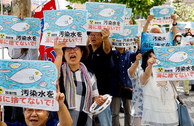 Protesters hold placards that read "No radiation contaminated water into the sea" during a rally against Japan's plan to discharge treated radioactive water from the tsunami-crippled Fukushima Daiichi nuclear plant into the ocean, in front of the headquarters of Tokyo Electric Power Company (TEPCO), the operator of the nuclear plant in Tokyo, Japan, August 24, 2023