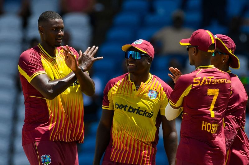 Jason Holder (L) and Rovman Powell (2L) of West Indies celebrate the dismissal of Suryakumar Yadav of India during the first T20I match between West Indies and India at Brian Lara Cricket Academy in Tarouba, Trinidad and Tobago, on 3 August, 2023