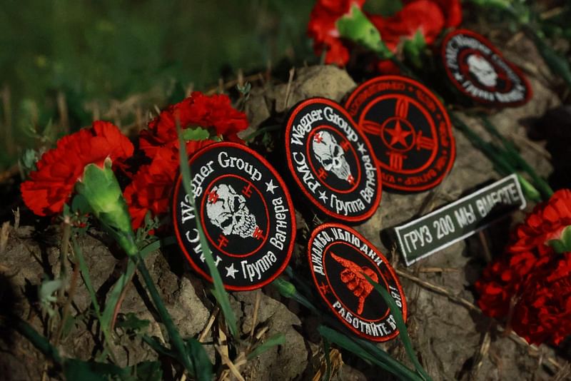 Flowers and patches bearing the logo of private mercenary group Wagner are seen at the makeshift memorial in front of the “PMC Wagner Centre” in Saint Petersburg, early on 24 August, 2023