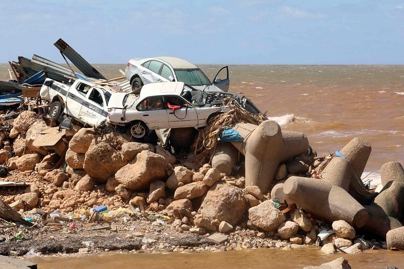 Cars are piled up atop wave breakers and the rubble of a building destroyed in flash floods after the Mediterranean storm "Daniel" hit Libya's eastern city of Derna, on 14 September, 2023