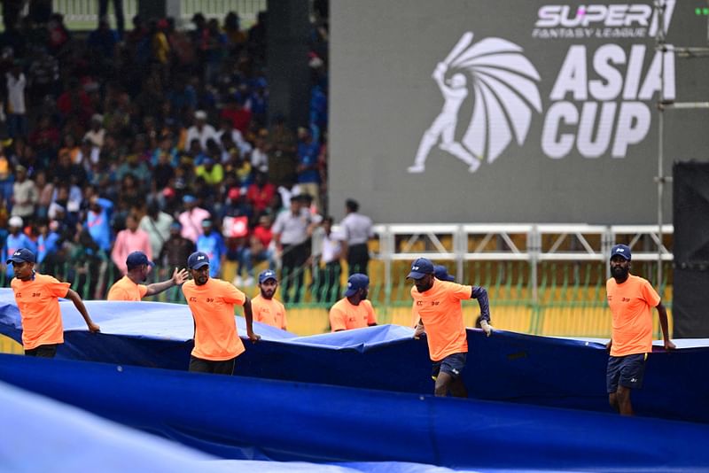 Ground staff cover the field as rain delays the start of the Asia Cup 2023 match between India and Sri Lanka at the R. Premadasa Stadium in Colombo on 17 September 2023