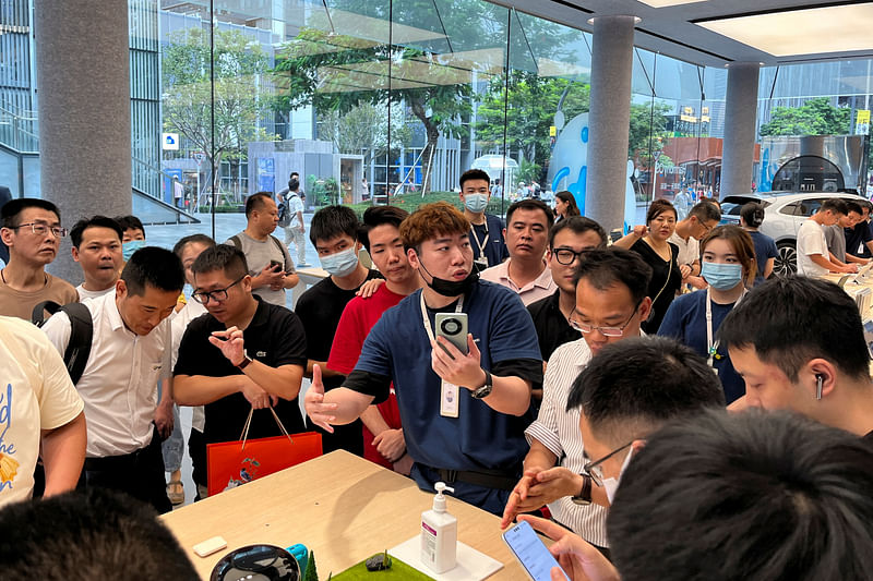 A staff member introduces the new Huawei Mate 60 smartphone to customers at the Huawei flagship store in Shenzhen, Guangdong province, China on 30 August, 2023