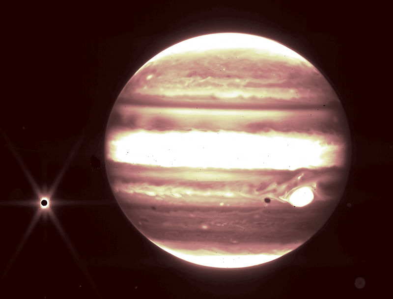 This handout image released by NASA on 21 September, 2023, shows the planet Jupiter (R) and it's moon Europa (L) as seen through The James Webb Space Telescope NIRCam instrument 2.12 micron filter.