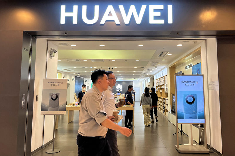 People walk past a Huawei store with advertisements for the Mate 60 series smartphones, at a shopping mall in Beijing, China on 30 August, 2023