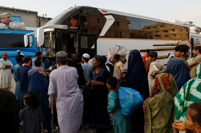 Afghan people gather to board a bus to return home, after Pakistan gave the last warning to undocumented migrants to leave, at a bus stop in Karachi, Pakistan October 25, 2023