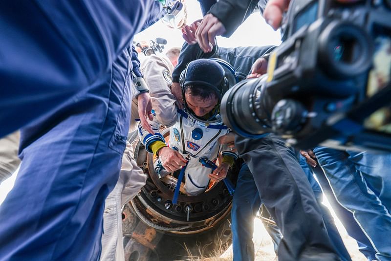 In this handout photograph taken and released by Roscosmos on 27 September, 2023, Expedition 69 NASA astronaut Frank Rubio (C) of the International Space Station (ISS) crew is helped by specialists after his landing in the Soyuz MS-23 capsule in a remote area near the town of Dzhezkazgan, Kazakhstan