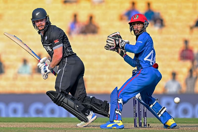 New Zealand's Glenn Phillips (L) along with Afghanistan's Ikram Alikhil watches the ball after playing a shot during the 2023 ICC Men's Cricket World Cup one-day international (ODI) match between New Zealand and Afghanistan at the MA Chidambaram Stadium in Chennai on October 18, 2023.