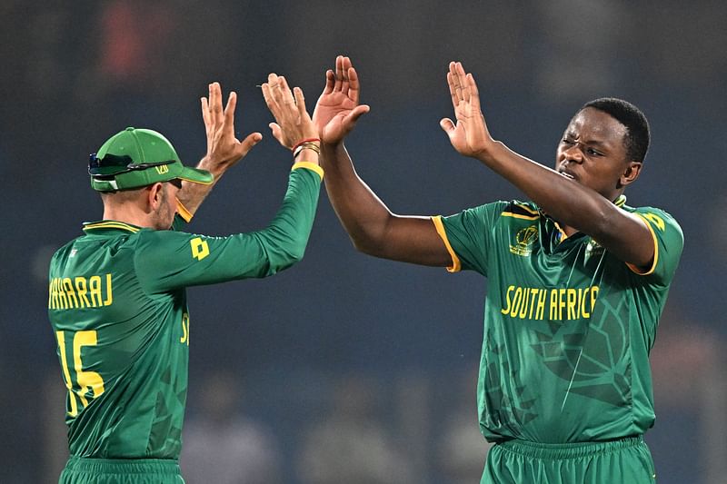 South Africa's Kagiso Rabada (R) celebrates with teammate Keshav Maharaj after taking the wicket of Sri Lanka's Matheesha Pathirana during the 2023 ICC Men's Cricket World Cup one-day international (ODI) match between South Africa and Sri Lanka at the Arun Jaitley Stadium in New Delhi on October 7, 2023.