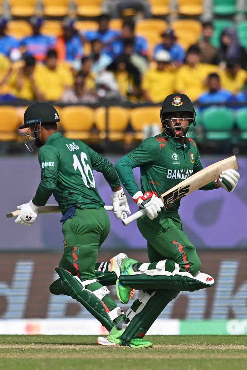 Bangladesh's Liton Das (L) and Mehidy Hasan Miraz run between the wickets during the 2023 ICC Men's Cricket World Cup one-day international (ODI) match between Bangladesh and Afghanistan at the Himachal Pradesh Cricket Association Stadium in Dharamsala on 7 October 2023.