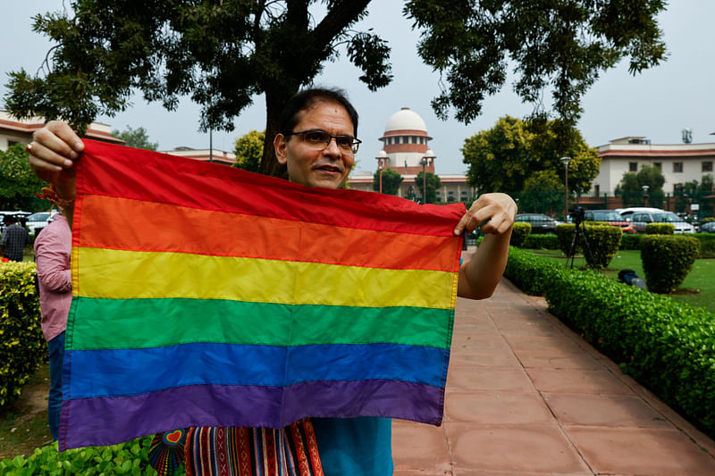 A writer and member of the lesbian, gay, bisexual and transgender community (LGBT community) holds the pride flag while waiting to hear the judgement on same-sex marriage by the Supreme Court in New Delhi, India, October 17, 2023