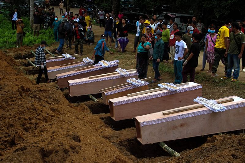 Coffins are lined up next to graves as a mass funeral takes place to bury victims of a military strike on a camp for displaced people near the northern Myanmar town of Laiza on 10 October, 2023