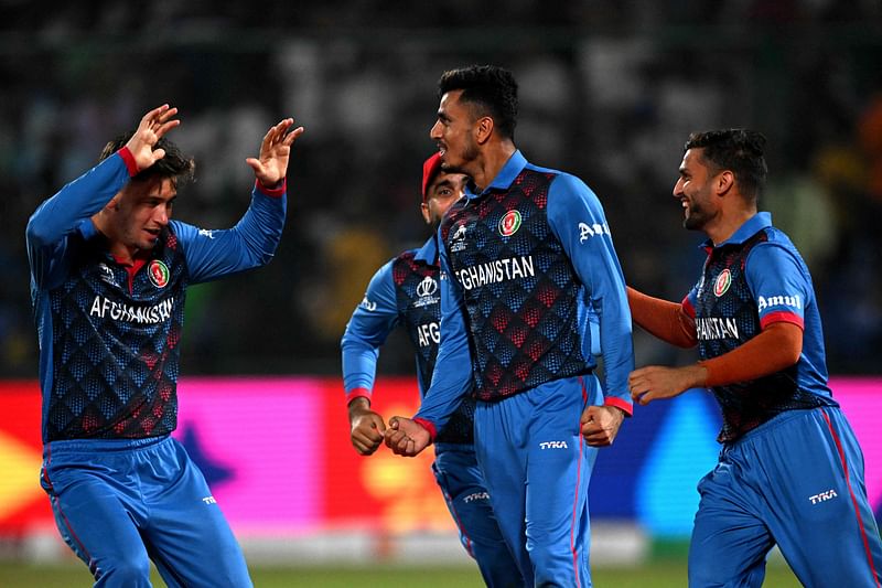 Afghanistan's Mujeeb Ur Rahman (2R) celebrates with teammates after taking the wicket of England's Harry Brook during the 2023 ICC Men's Cricket World Cup one-day international (ODI) match between England and Afghanistan at the Arun Jaitley Stadium in New Delhi on 15 October, 2023