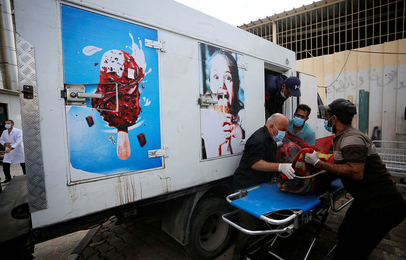 People move the body of a Palestinian, who was killed in Israeli strikes, from an ice cream truck where it was kept, as the hospital morgues are packed, amid the ongoing Israeli-Palestinian conflict, in the central Gaza Strip October 15, 2023