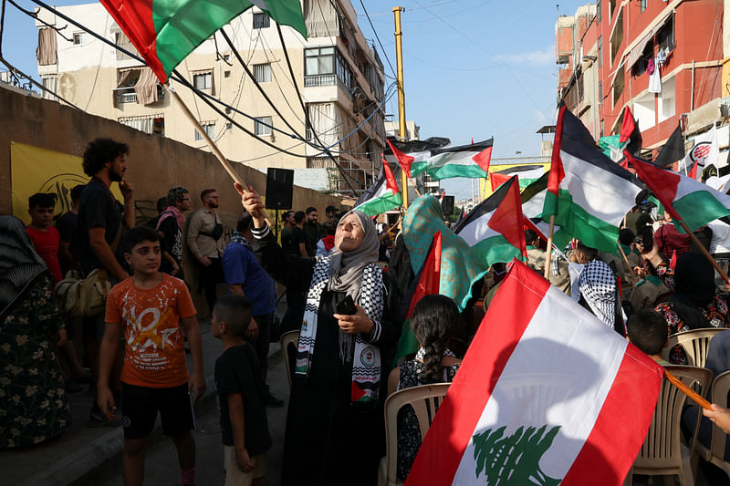 Samira Hassan Mahmoud holds a flag as Palestinian refugees attend a rally to express solidarity with Palestinians in Gaza, in the Burj al-Barajneh refugee camp in Beirut, Lebanon 11 October, 2023.