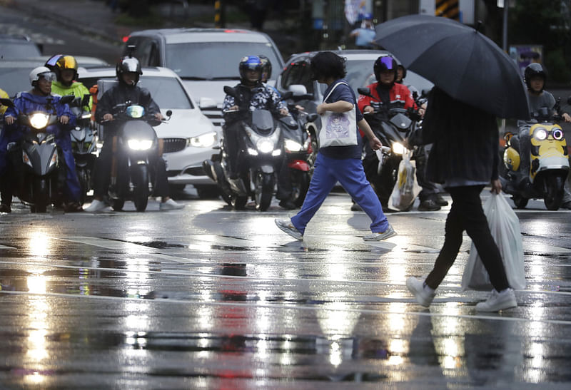 People walk in the rain as Typhoon Koinu approaches to Taiwan in Taipei, Taiwan, Wednesday, Oct. 4, 2023.