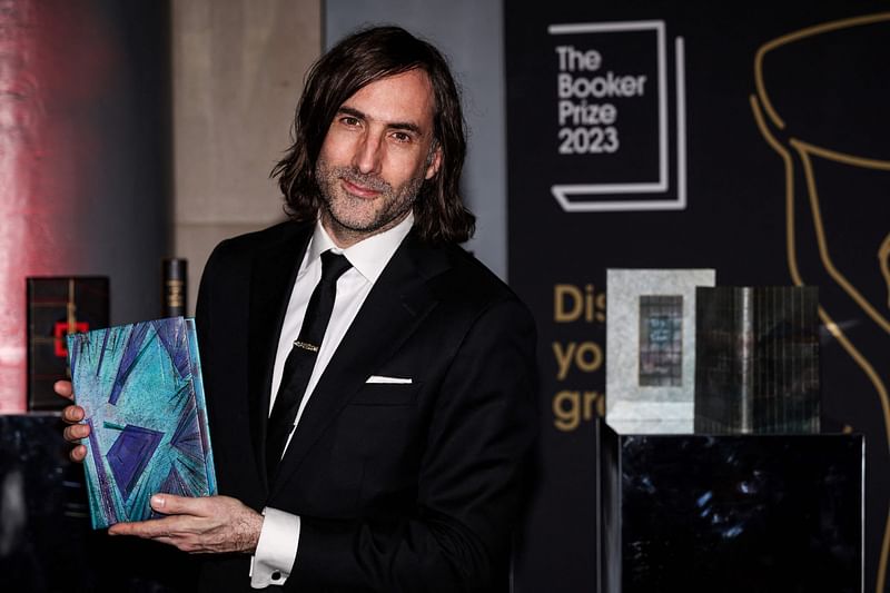 Irish writter Paul Lynch and Booker Prize 2023 shortlisted author poses with his specially bound book copy "Prophet Song" on the red carpet upon arrival for the Booker Prize Award announcement ceremony, at the Old Billingsgate, in central London, on 26 November, 2023