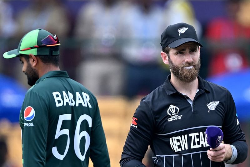 New Zealand's captain Kane Williamson (R) and Pakistan's captain Babar Azam look on after the toss, before the start of the 2023 ICC Men's Cricket World Cup one-day international (ODI) match between New Zealand and Pakistan at the M. Chinnaswamy Stadium in Bengaluru on 4 November, 2023