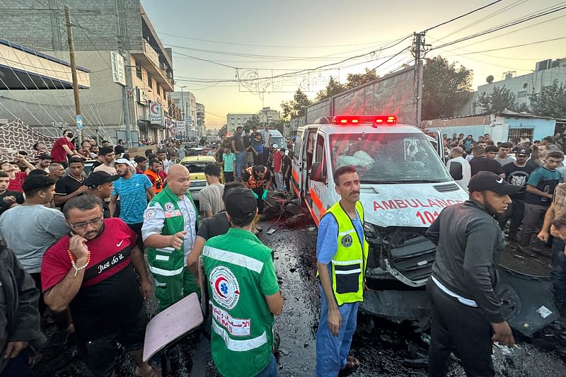 A dead horse lies on the ground as people gather around an ambulance damaged in a reported Israeli strike in front of Al-Shifa hospital in Gaza City on 3 November, 2023,