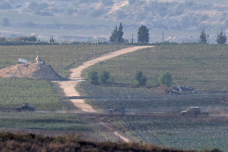 This picture taken on 17 November, 2023 from a position along the border with the Gaza Strip in southern Israel shows an Israeli military vehicle patrolling inside the Palestinian enclave amid ongoing battles between Israel and the Palestinian group Hamas