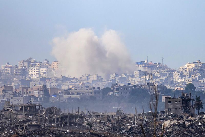 This picture taken from southern Israel near the border with Gaza shows smoke billowing over destroyed buildings following following Israeli strike onn the Palestinian territory on 20 November, 2023