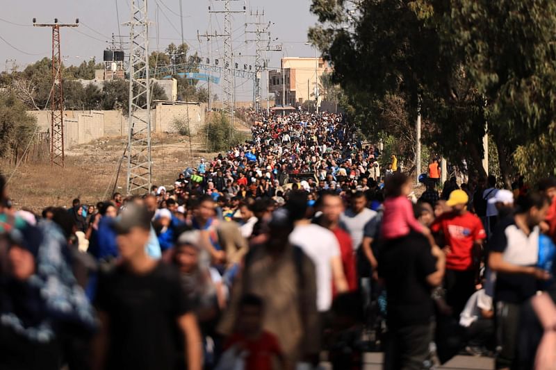 Palestinians families fleeing Gaza City and other parts of northern Gaza towards the southern areas, walk along a road on 10 November, 2023.