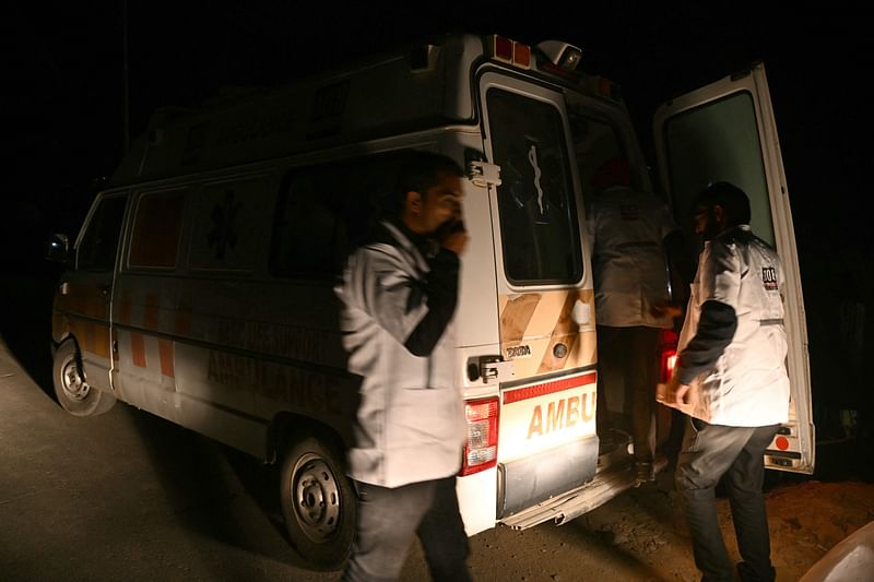 Paramedics wait near the tunnel where rescuers work on the final stage to reach workers trapped in the Silkyara road tunnel, days after it collapsed in the Uttarkashi district of India, on 22 November, 2023