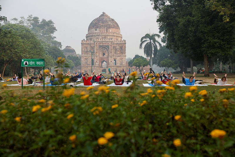 People perform yoga at Lodhi Garden on a smoggy morning in New Delhi, India, October 31, 2023.