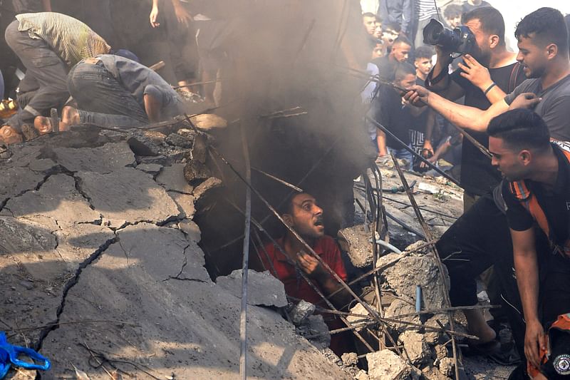 Palestinians check the rubble of a building in Khan Yunis on 6 November, 2023.Thousands of civilians, both Palestinians and Israelis, have died since 7 October, 2023