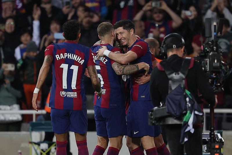 Barcelona's Polish forward #09 Robert Lewandowski celebrates with teammates scoring his team's second goal during the Spanish league football match between FC Barcelona and Deportivo Alaves at the Estadi Olimpic Lluis Companys in Barcelona on 12 November, 2023