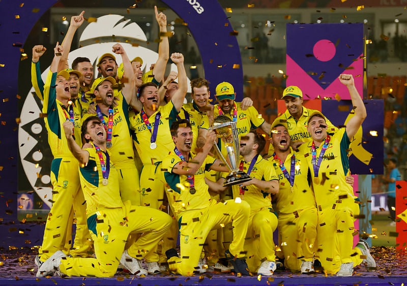 Australia's Pat Cummins celebrates with the trophy and teammates after winning the ICC Cricket World Cup