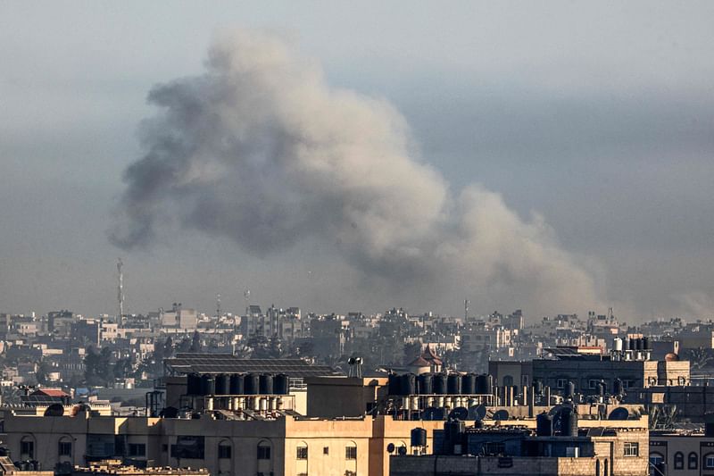 A smoke plume erupts over Khan Yunis as seen from Rafah in the southern Gaza strip during Israeli bombardment on 29 December, 2023, amid continuing battles between Israel and the Palestinian Hamas militant group.