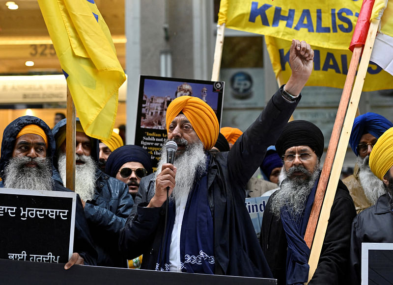 A demonstrator uses a microphone as others hold flags and signs as they protest outside India's consulate, a week after Canada's Prime Minister Justin Trudeau raised the prospect of New Delhi's involvement in the murder of Sikh separatist leader Hardeep Singh Nijjar, in Vancouver, British Columbia, Canada September 25, 2023