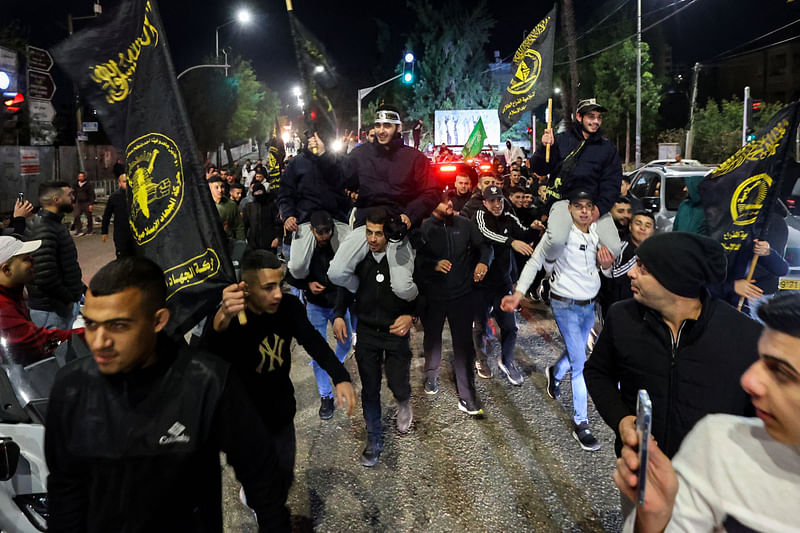 Newly released prisoners are carried by supporters holding the flag of militant group Islamic Jihad, during a welcome ceremony following the release of Palestinian prisoners from Israeli jails in exchange for Israeli hostages held in Gaza by the Palestinian militant group and Hamas since the 7 October attacks, in Ramallah in the occupied West Bank early on 1 December, 2023