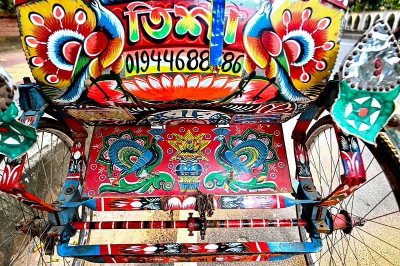 This photograph taken on 17 December, 2023 shows a bicycle rickshaw adorned with colourful artwork in Dhaka.