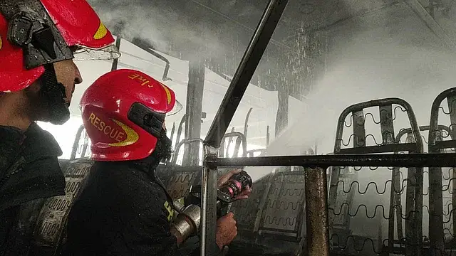 Fire fighters are dousing the flame of a passenger bus at Shahbagh intersection in the capital on Wednesday.