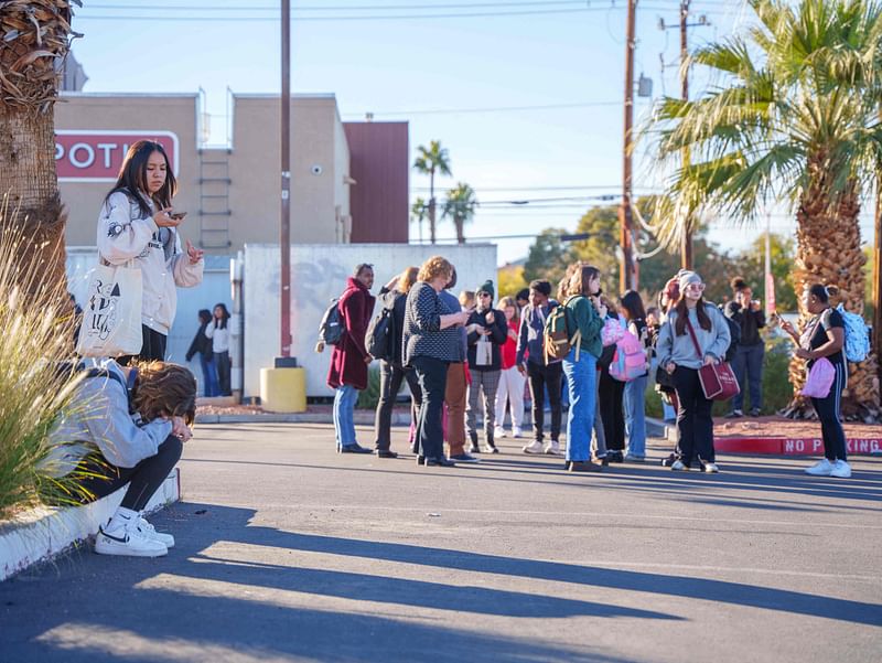 People wait on the outskirts of the UNLV campus after a shooting on 6 December, 2023 in Las Vegas, Nevada. According to Las Vegas Metro Police, a suspect is dead and multiple victims are reported after a shooting on the campus