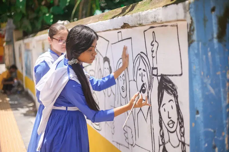 A school student paints a mural calling for action against climate change and environmental pollution on a roadside wall in Cox's Bazar, Bangladesh, November 2021.