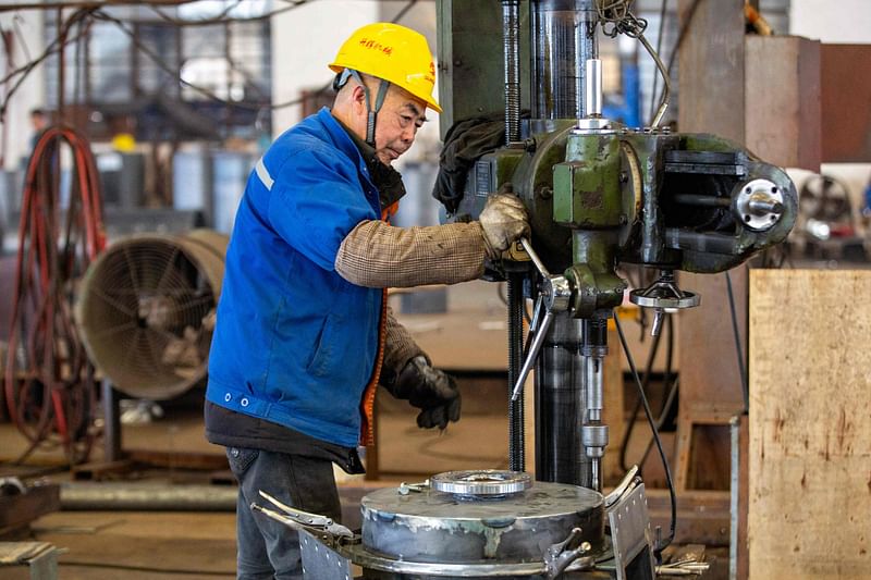 An employee produces building material processing equipment at a factory in Nantong, in China's eastern Jiangsu province on 5 December 2023.