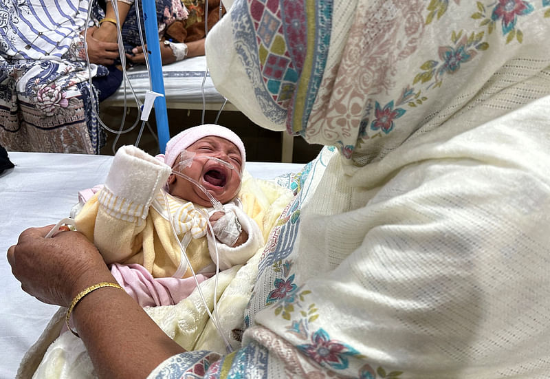 One-month-old baby girl, Noor cries while being comforted by her grandmother inside the paediatric ward at Sir Ganga Ram Hospital where she is being treated for pneumonia amidst soaring air pollution in Lahore, Pakistan, December 4, 2023