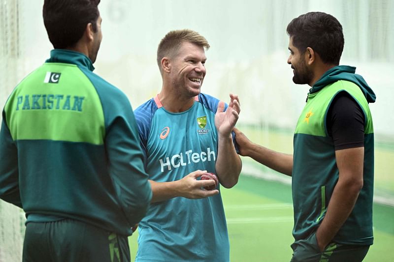 Australia's David Warner (C) shares a joke with Pakistan's batsman Babar Azam (R) and bowling coach Umar Gul (L) during a training session at the Melbourne Cricket Ground (MCG) in Melbourne on December 25, 2023, on the eve of the second cricket Test match between Australia and Pakistan