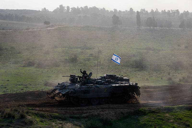 Israeli soldiers ride in an armoured personnel carrier (APC) near the border with Gaza, after a temporary truce between Israel and the Palestinian Islamist group Hamas expired, in Israel, 1 December 2023.