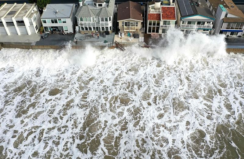 An aerial view of Pacific Ocean waves crashing against a seawall protecting homes on 30 December, 2023 near Ventura, California. Dangerous surf churned up by storms in the Pacific is impacting much of California’s coastline with coastal flooding possible in some low-lying areas